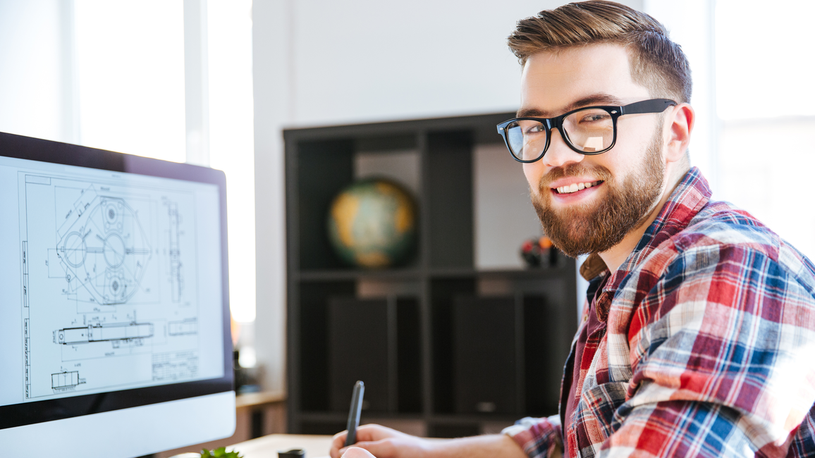 The picture shows a doctoral student working at a computer.